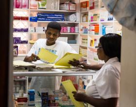 Source - PSI. Pharmacy workers discussing the various commodities available. 